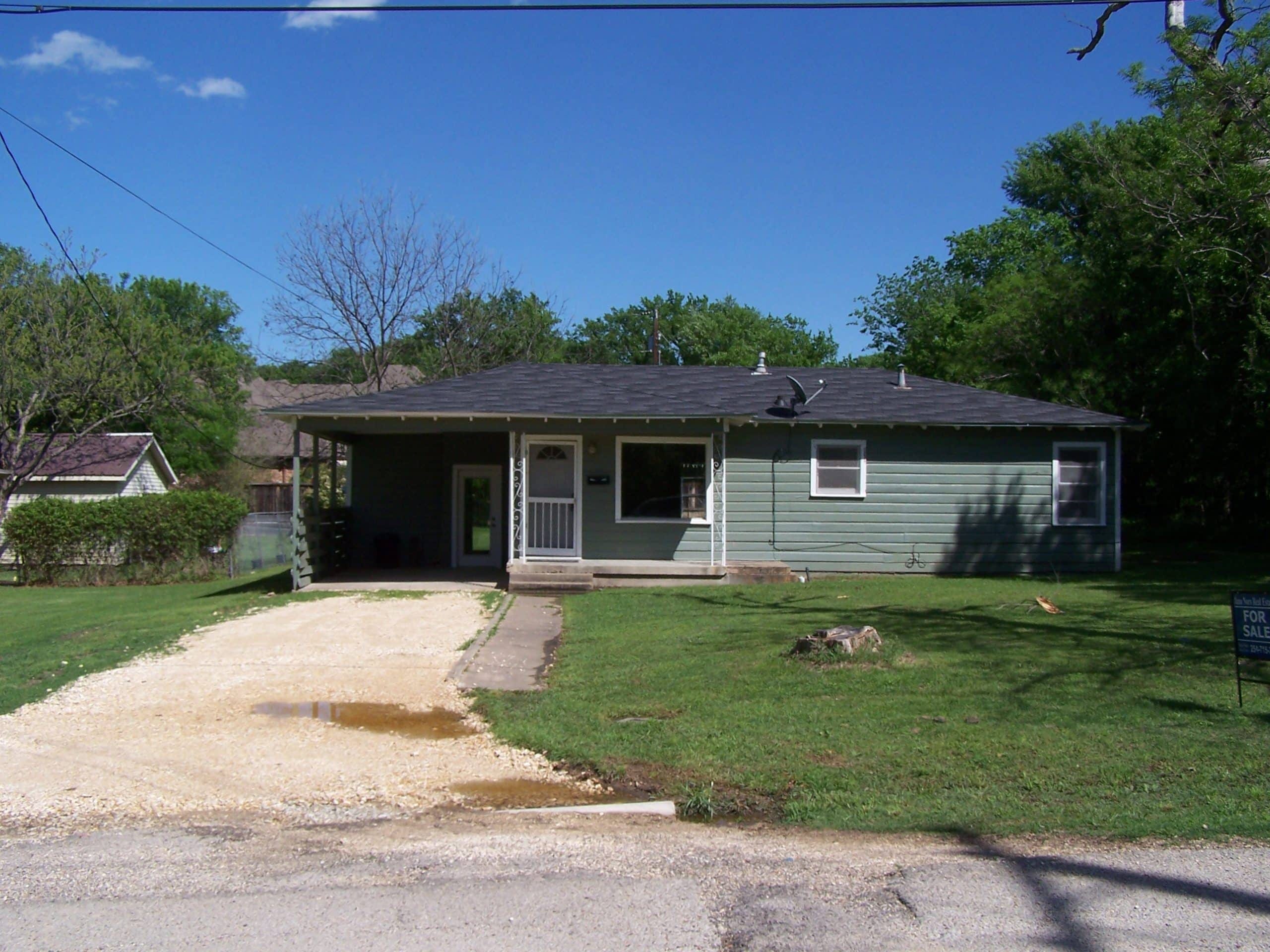 Cozy green house with front porch and driveway in Hillsboro, West Hill County.