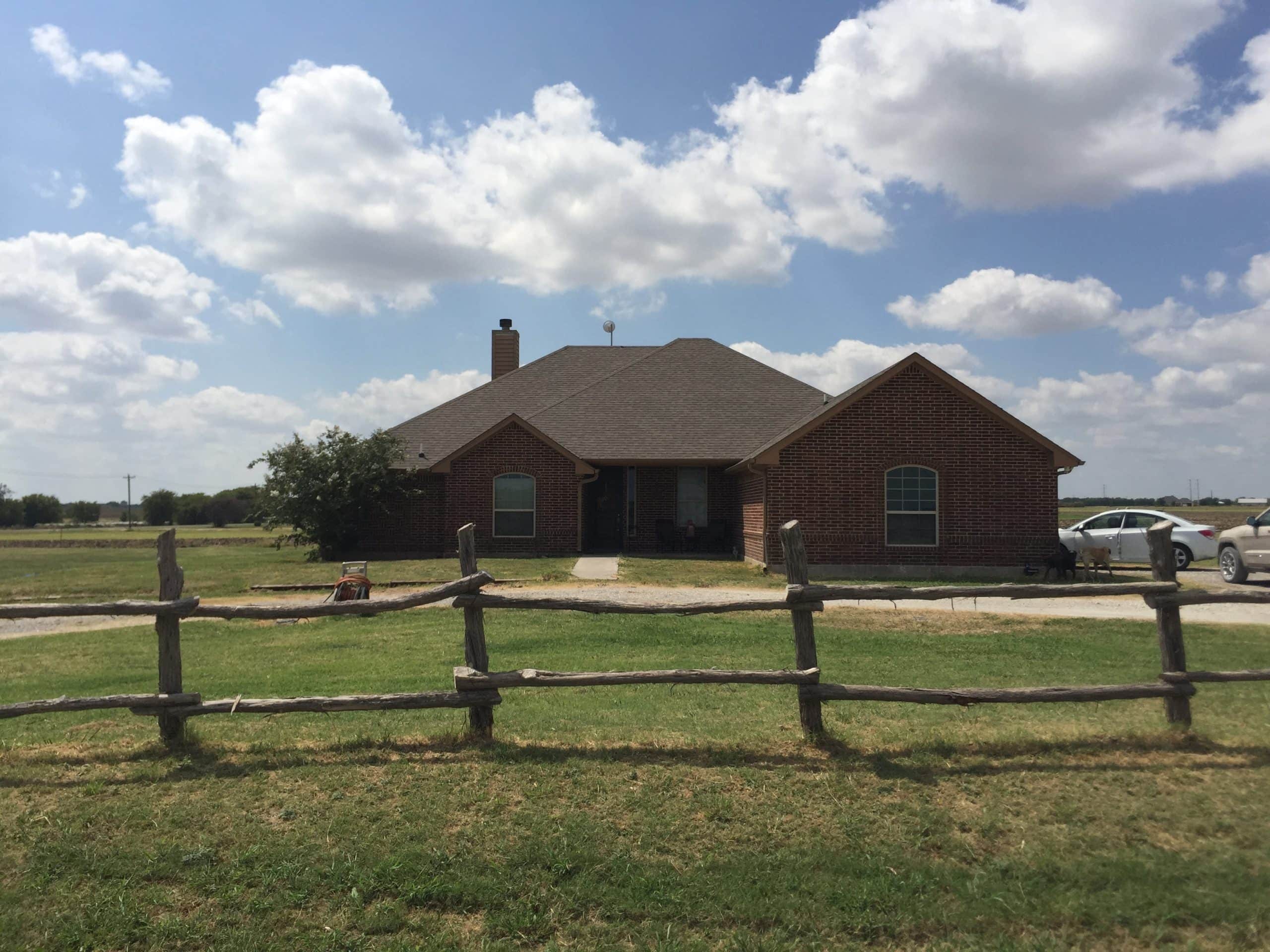 House in Abbott, Texas with a wooden fence and open sky.