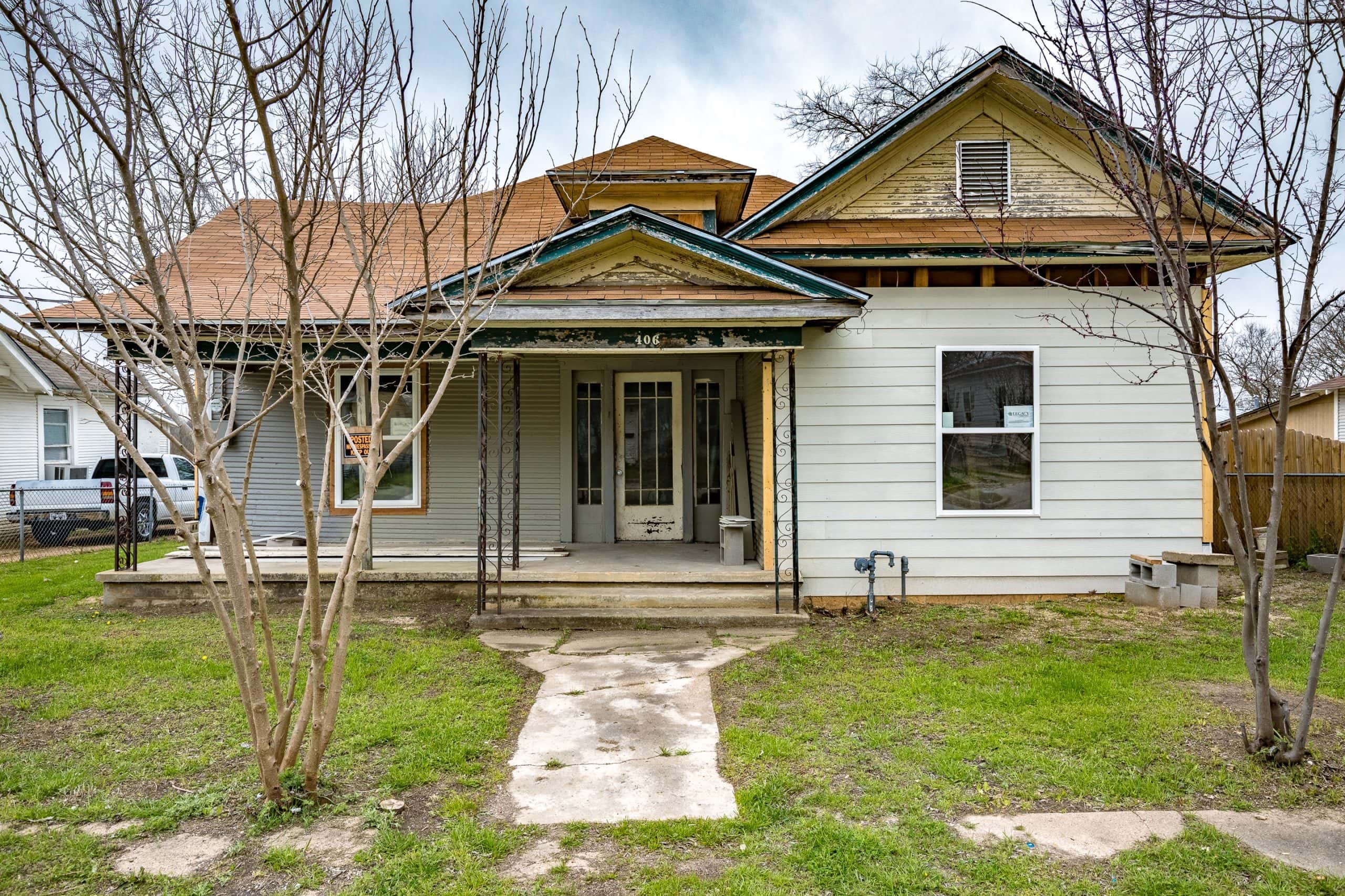 Spacious front yard with mature trees and a welcoming porch.