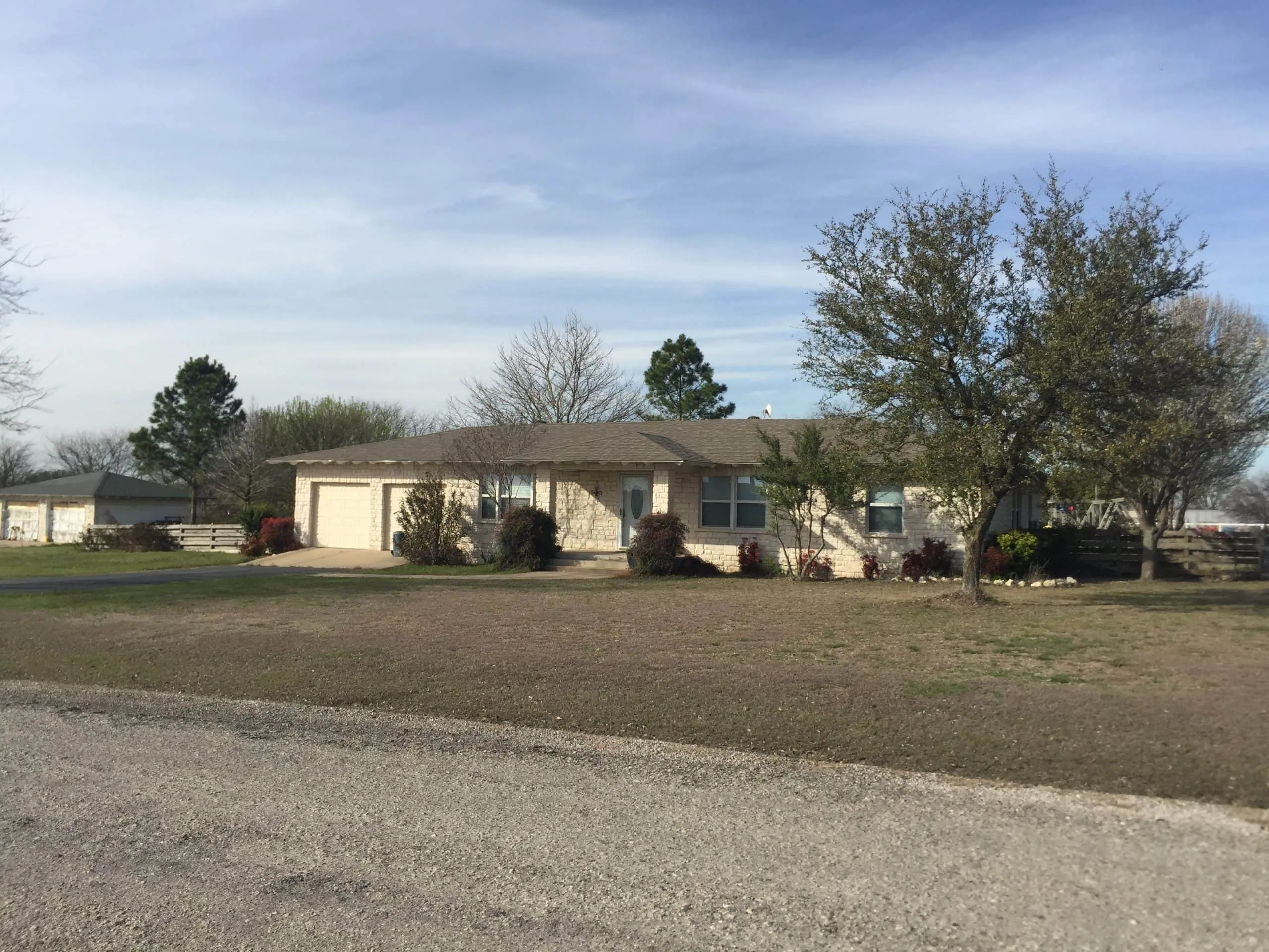 House exterior with trees and lawn in Abbott, West Hill County.